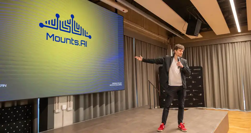 Patryk Owczarz presenting Mounts.AI on stage at an industry event